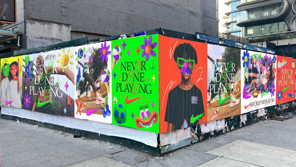 Esquina de dos calles donde se ve un muro totalmente empapelado por carteles con una campaña de Nike realizada con tintas neón.