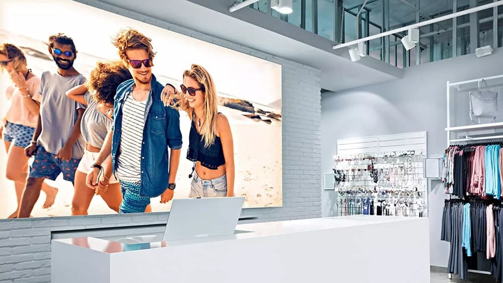 Interior de tienda de ropa con la imagen de una caja de luz, impresa con impresión digital de gran formato, detrás de un mostrador